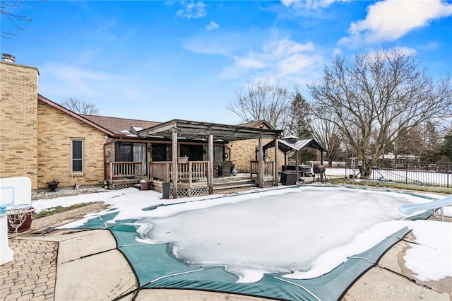 snow covered rear of property featuring a pergola