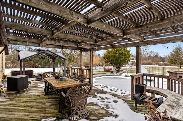 snow covered deck featuring a gazebo, a covered pool, and a pergola