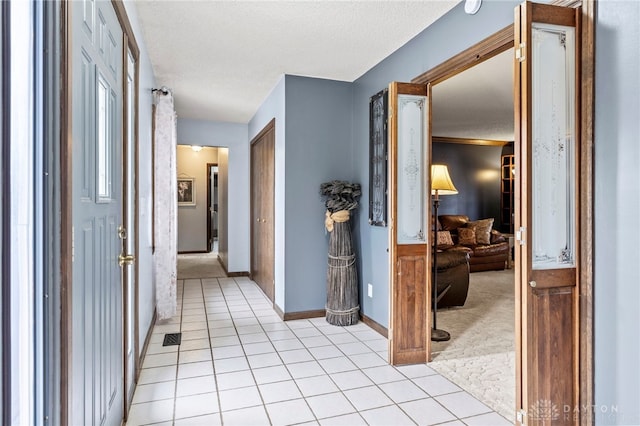 hallway with light tile patterned flooring and a textured ceiling