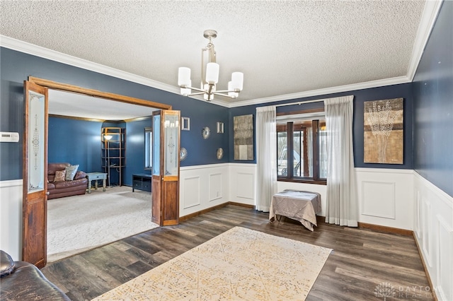 interior space with ornamental molding, dark hardwood / wood-style floors, a textured ceiling, and a notable chandelier