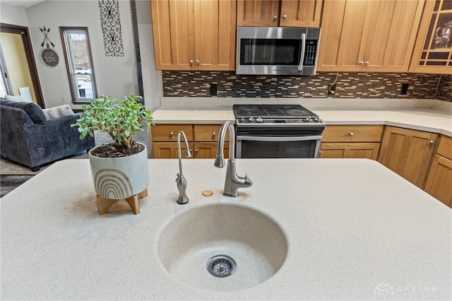 kitchen with tasteful backsplash, appliances with stainless steel finishes, vaulted ceiling, and sink