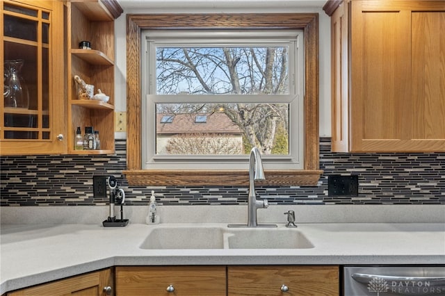 kitchen featuring sink, stainless steel dishwasher, and backsplash