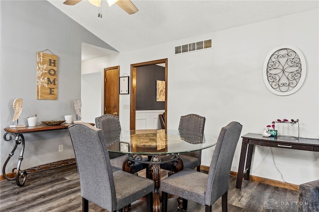 dining room featuring dark hardwood / wood-style flooring, ceiling fan, lofted ceiling, and a textured ceiling