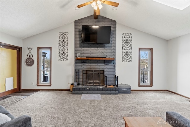 living room with lofted ceiling, ceiling fan, carpet, a textured ceiling, and a brick fireplace