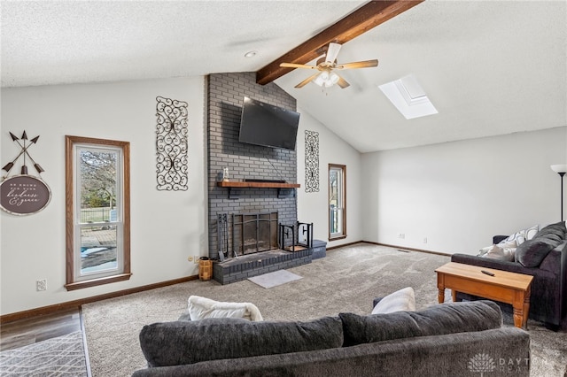 carpeted living room with a brick fireplace, a textured ceiling, and vaulted ceiling with skylight