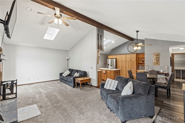 living room featuring lofted ceiling with skylight, dark carpet, and ceiling fan