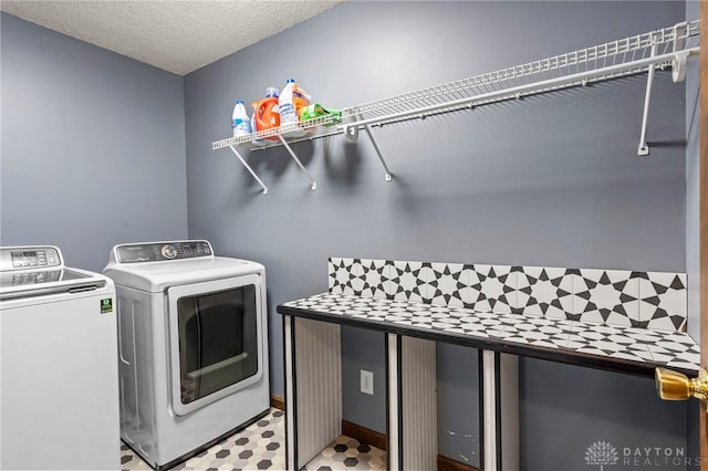 clothes washing area featuring washing machine and dryer and a textured ceiling