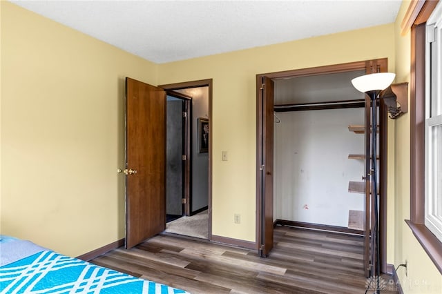 unfurnished bedroom featuring dark hardwood / wood-style floors, a closet, and a textured ceiling