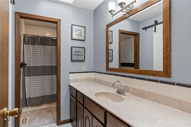 bathroom featuring vanity, curtained shower, and a textured ceiling