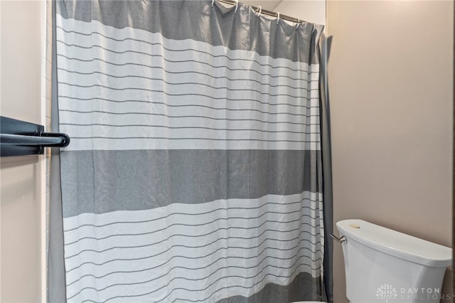 bathroom with curtained shower and toilet