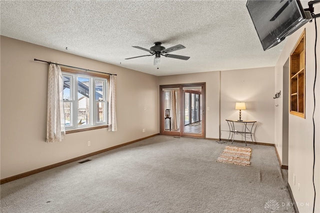 spare room featuring ceiling fan, carpet floors, and a textured ceiling