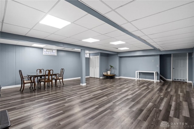 basement with a paneled ceiling and wood-type flooring