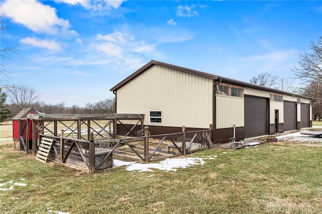 view of property exterior with a garage, an outdoor structure, and a yard