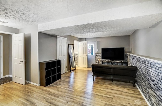 living room with a textured ceiling and light hardwood / wood-style floors