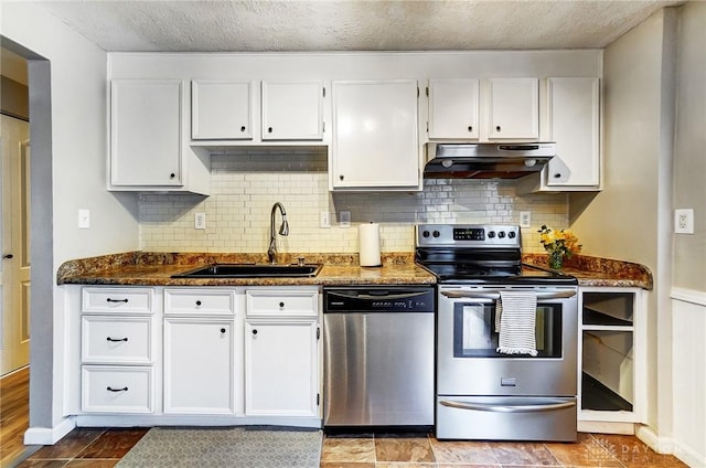 kitchen with stainless steel appliances, sink, dark stone countertops, and white cabinets