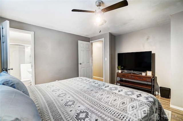 bedroom with connected bathroom, hardwood / wood-style floors, and ceiling fan