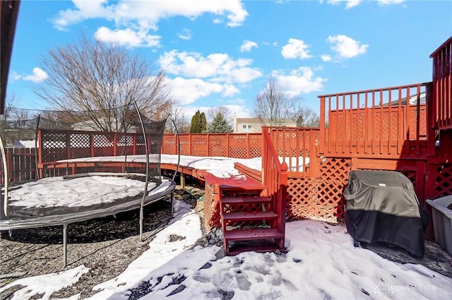 snow covered deck featuring a grill and a trampoline