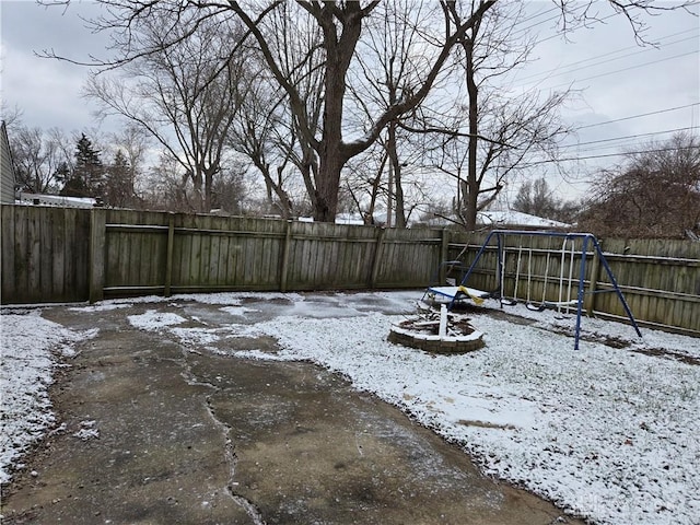 yard layered in snow featuring a playground