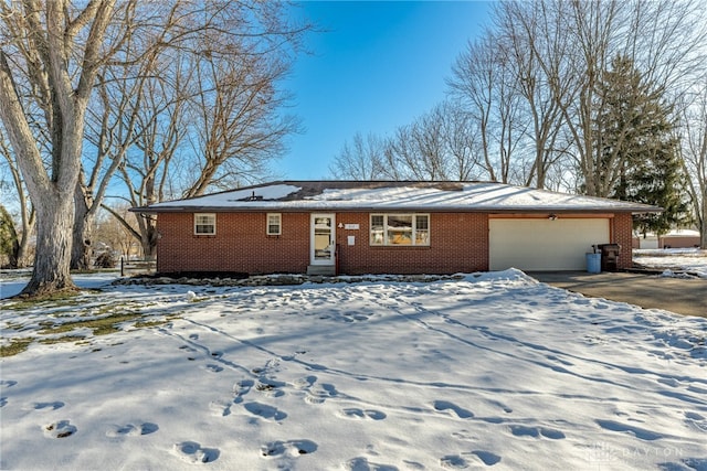 ranch-style home featuring a garage, driveway, and brick siding