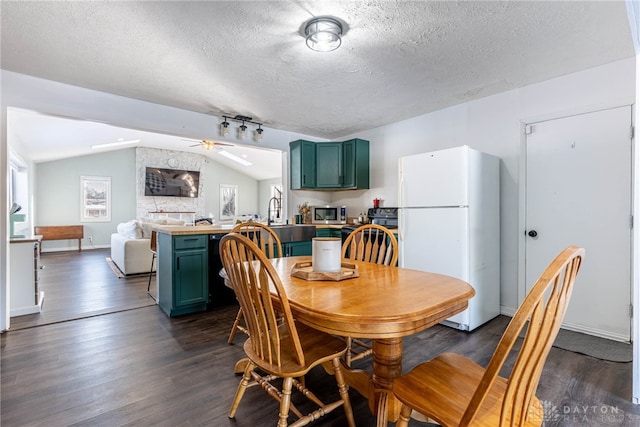 dining area featuring a textured ceiling, baseboards, vaulted ceiling, and dark wood-type flooring