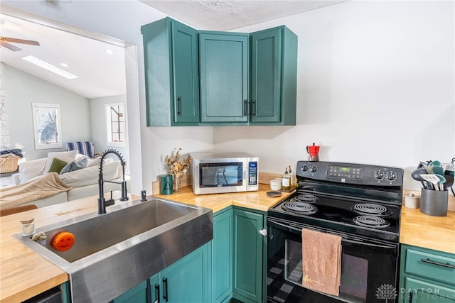 kitchen featuring butcher block countertops, a sink, open floor plan, black electric range, and stainless steel microwave