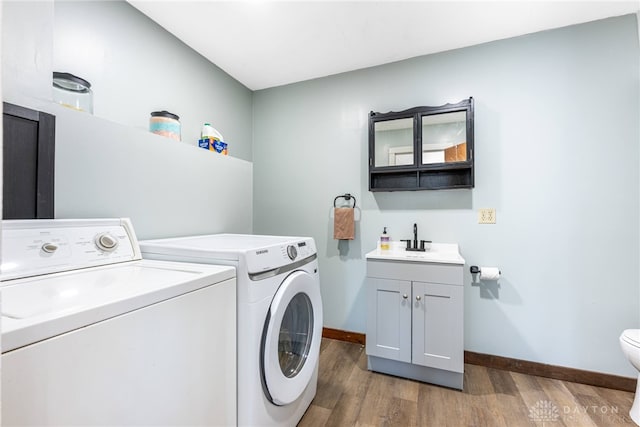 laundry room with laundry area, a sink, baseboards, independent washer and dryer, and dark wood finished floors