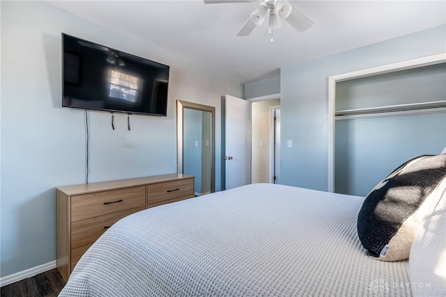 bedroom with ceiling fan, baseboards, dark wood finished floors, and a closet