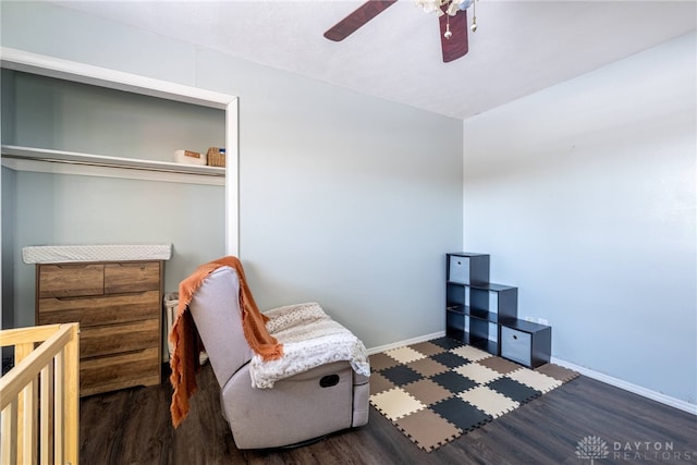 living area with dark wood-style floors, baseboards, and a ceiling fan