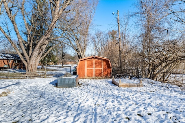 snowy yard with a storage shed