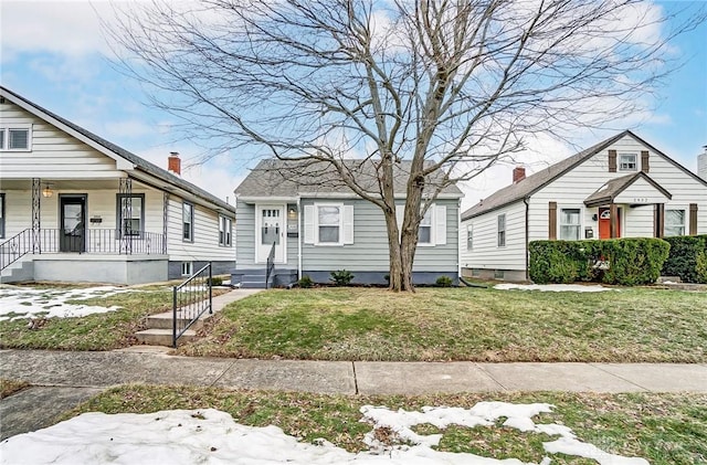 bungalow-style home with covered porch and a front lawn