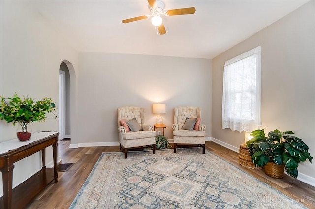 sitting room with ceiling fan and wood-type flooring