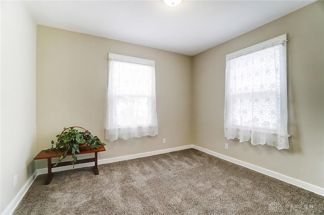 carpeted spare room featuring plenty of natural light