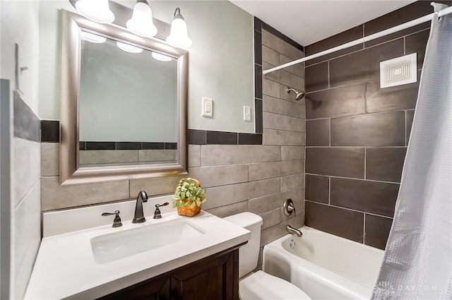 full bathroom featuring shower / tub combo with curtain, vanity, toilet, and tile walls