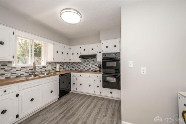 kitchen featuring sink, tasteful backsplash, black appliances, light hardwood / wood-style floors, and white cabinets