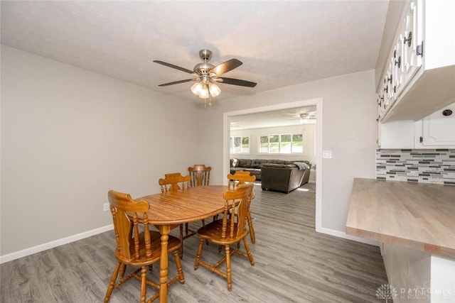 dining area with wood-type flooring and ceiling fan