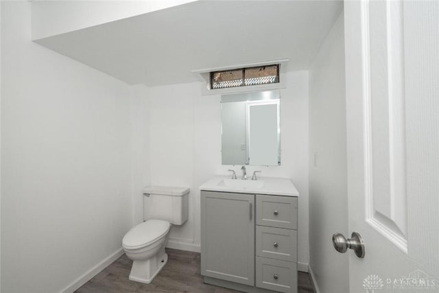 bathroom featuring vanity, wood-type flooring, and toilet