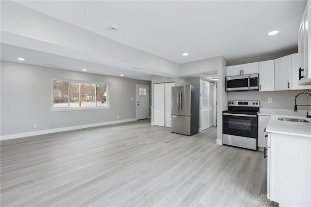 kitchen with white cabinetry, sink, light hardwood / wood-style flooring, and stainless steel appliances