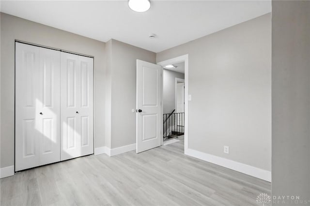 unfurnished bedroom featuring a closet and light wood-type flooring