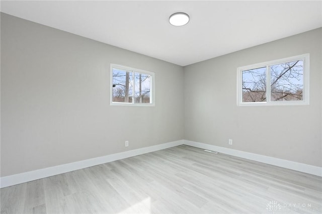 unfurnished room featuring light wood-type flooring and a wealth of natural light