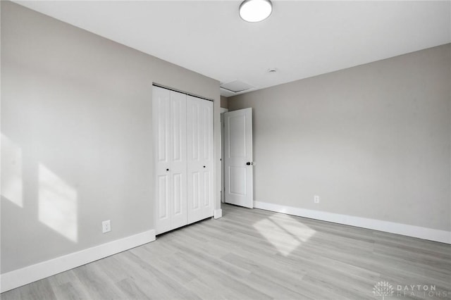 unfurnished bedroom with a closet and light wood-type flooring