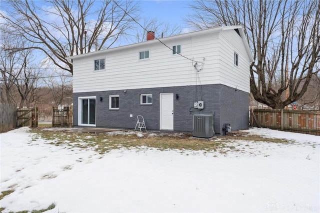 snow covered back of property with central air condition unit