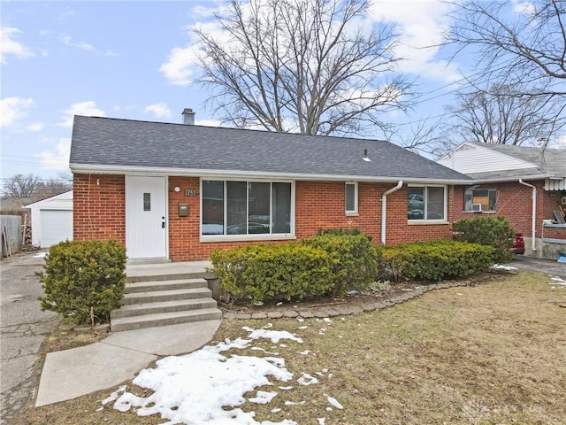 view of front of home featuring a garage and an outbuilding