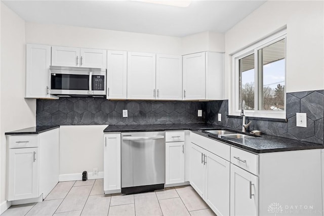 kitchen with backsplash, appliances with stainless steel finishes, sink, and white cabinets