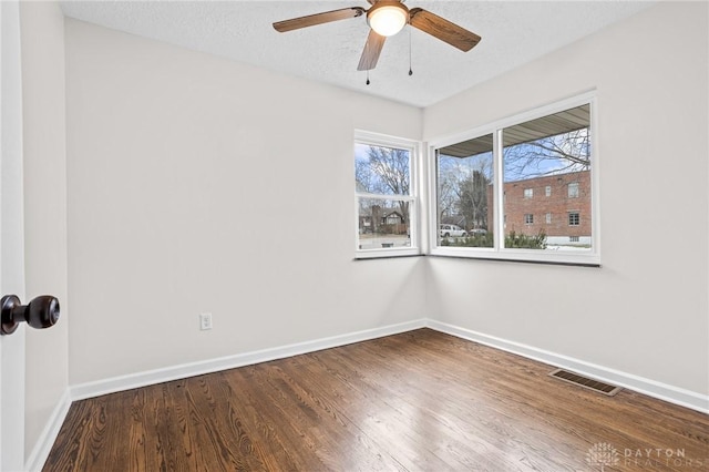 spare room featuring ceiling fan, hardwood / wood-style floors, and a textured ceiling