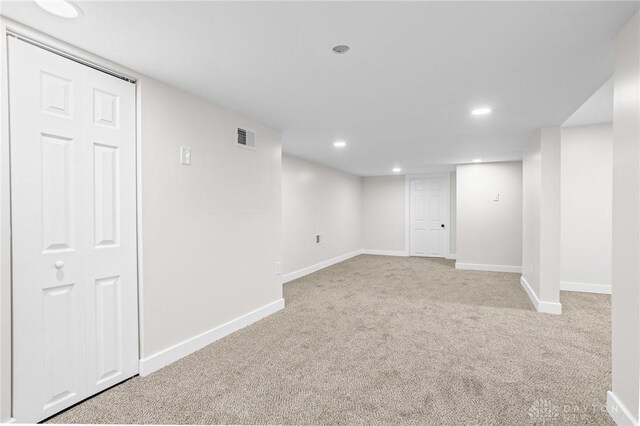 basement featuring light colored carpet