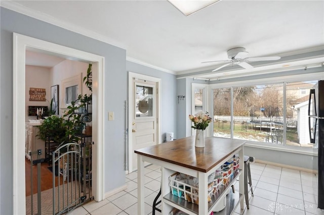 dining space with crown molding, light tile patterned flooring, and ceiling fan