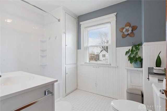 bathroom with vanity, a shower, and toilet