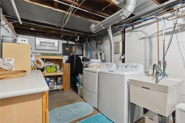 clothes washing area featuring separate washer and dryer and sink