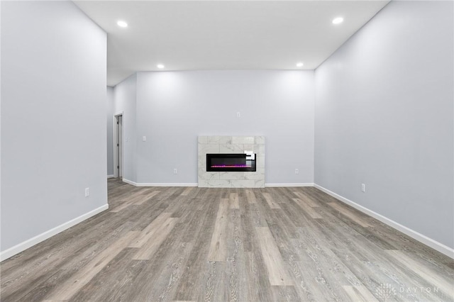 unfurnished living room featuring a fireplace and light hardwood / wood-style floors