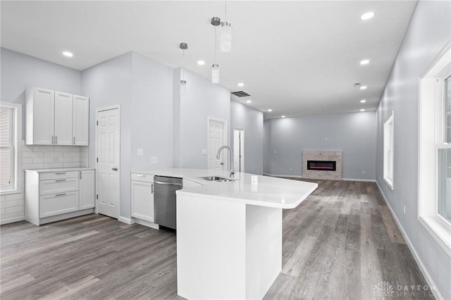 kitchen featuring pendant lighting, sink, dishwasher, white cabinetry, and kitchen peninsula